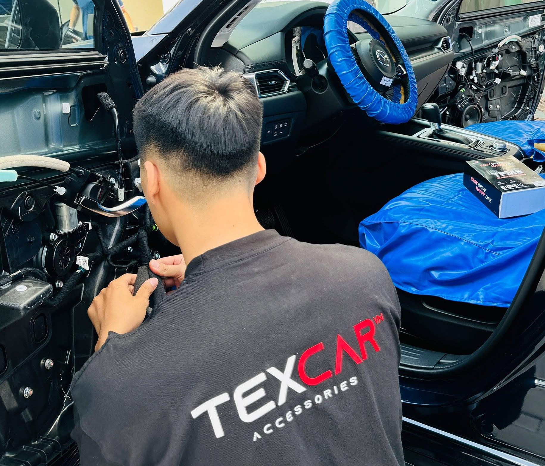 Kỹ thuật viên TEXCAR tháo ốp cửa Mazda CX-5 tại xưởng